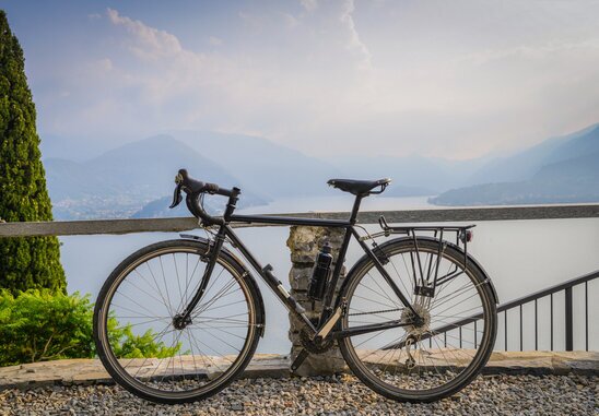 Ciclista su strada panoramica sopra Bellagio con vista Lago di Como